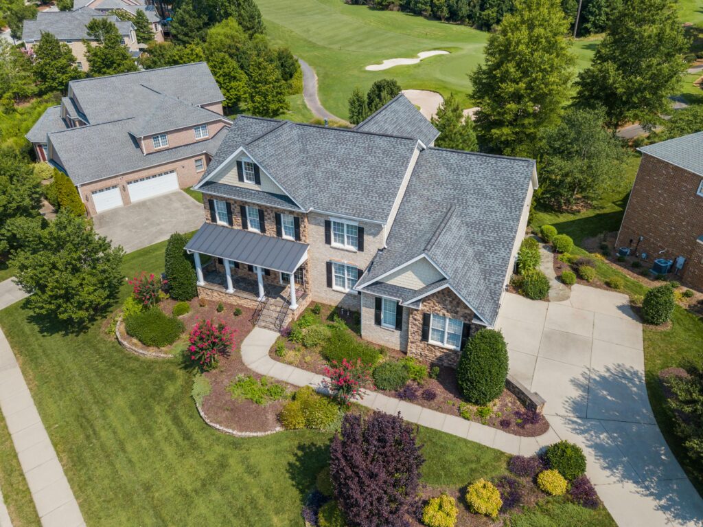Aerial view of a residential home with asphalt shingle roofing commonly seen in suburban neighborhoods