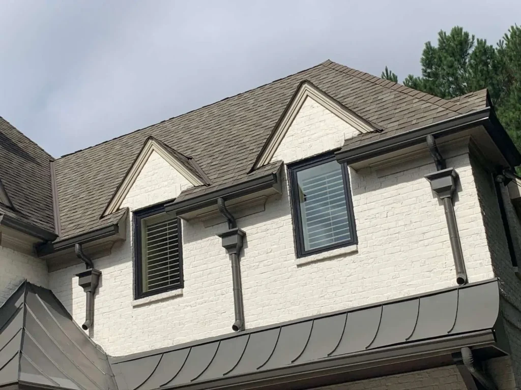 Architectural shingles and standard shingles displayed side by side on a residential roof